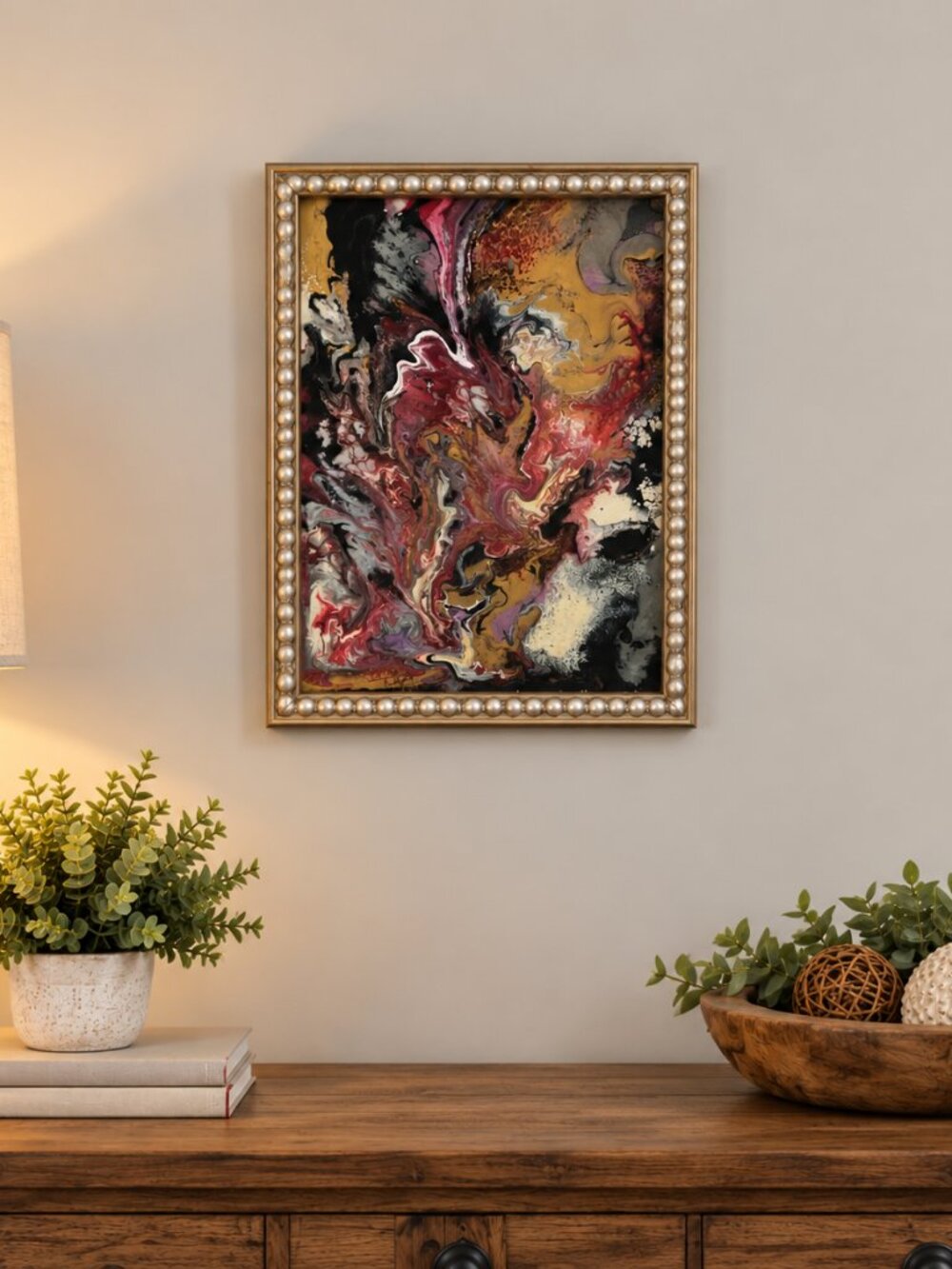 abstract acrylic pour painting in an ornate, beaded metallic frame